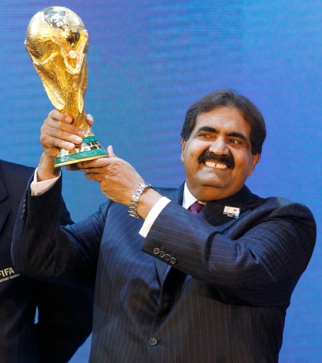 Hamad bin Khalifa Al Thani holding the 2022 FIFA World Cup trophy